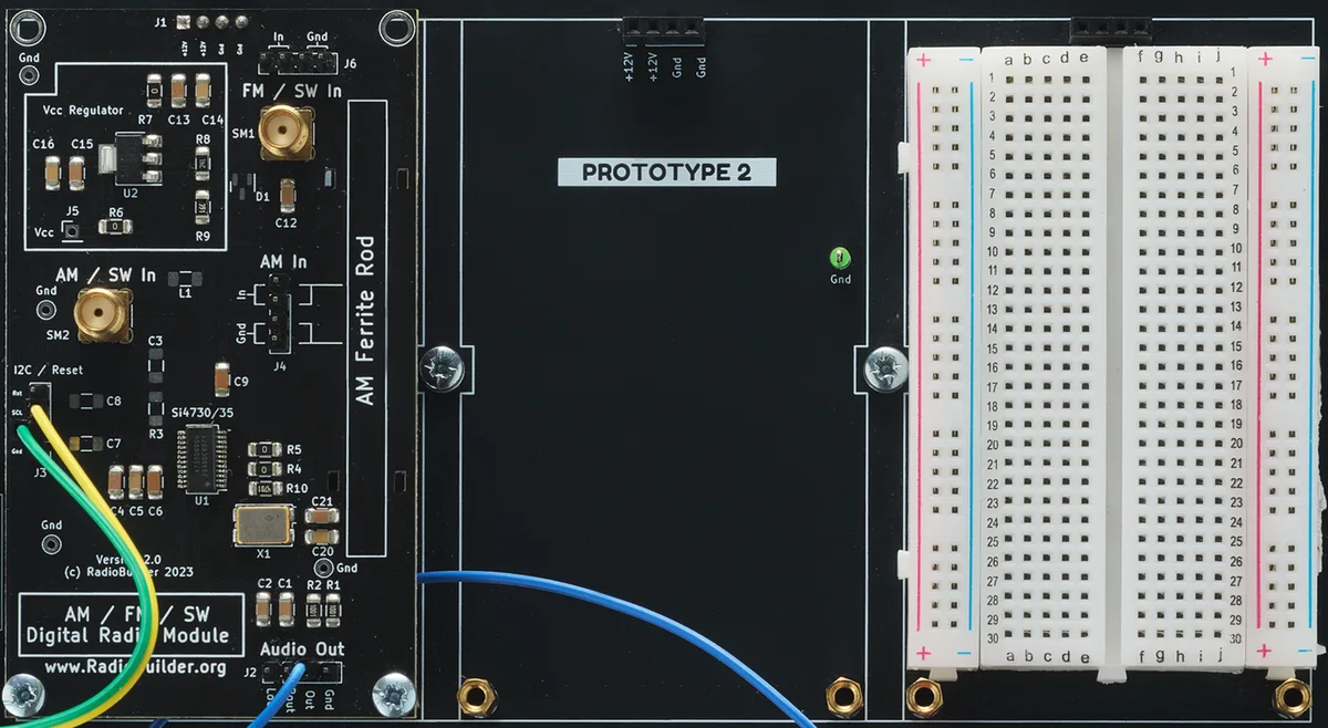 Prototype area: full-size breadboard wired into the signal path, shown here with an AM/FM/SW digital radio module plugged in
